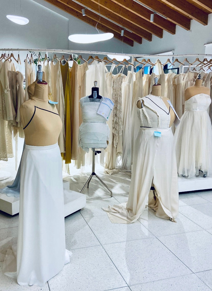 View of the Larimeloom studio with dress forms displaying work-in-progress custom wedding dress designs in various stages of creation
