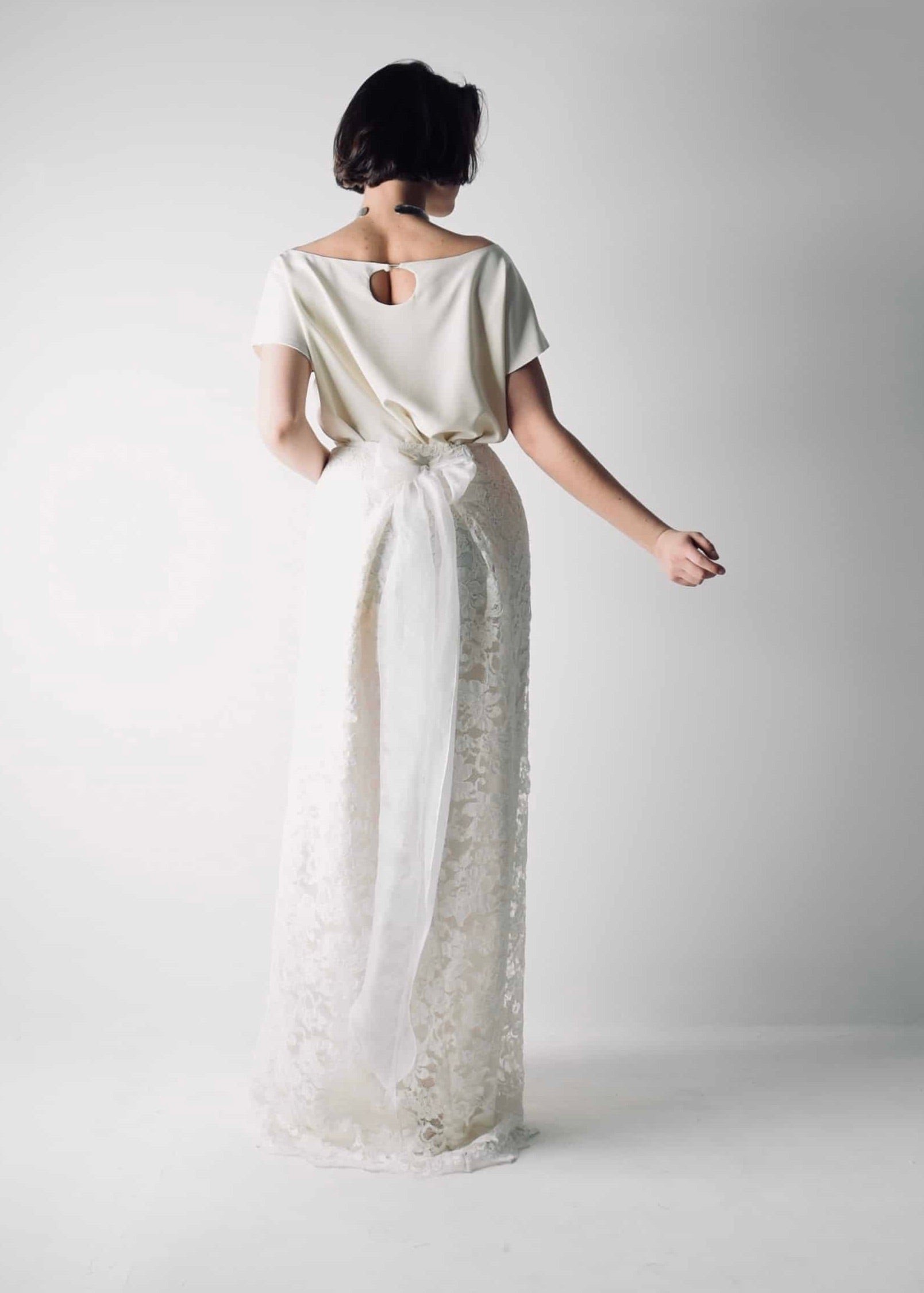 Romantic lace wedding skirt, with an A-line cut, paired with a separate soft silk bridal blouse, for a simple wedding dress look - back view